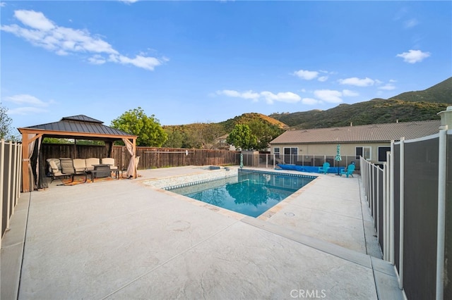 view of swimming pool with a patio area, a gazebo, a fenced in pool, a fenced backyard, and a mountain view