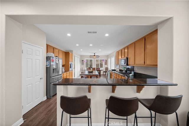 kitchen with visible vents, dark wood-style flooring, a peninsula, recessed lighting, and appliances with stainless steel finishes