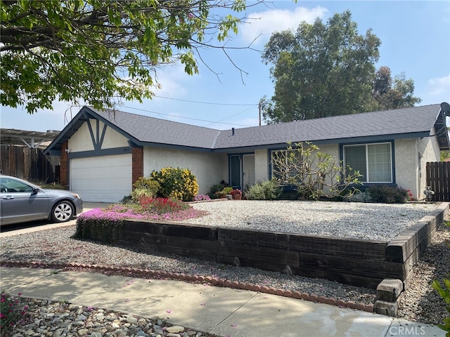 ranch-style home featuring fence, stucco siding, an attached garage, and roof with shingles
