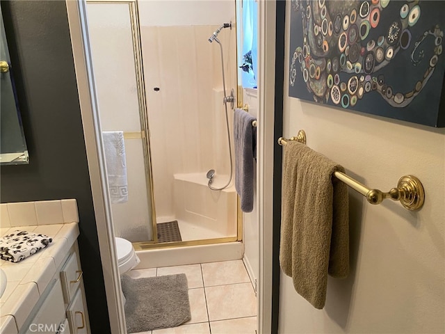 bathroom with vanity, toilet, tile patterned flooring, and a stall shower