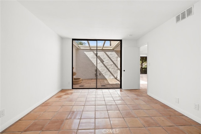 spare room with light tile patterned floors and baseboards