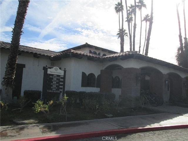 mediterranean / spanish-style house featuring stucco siding and a tile roof