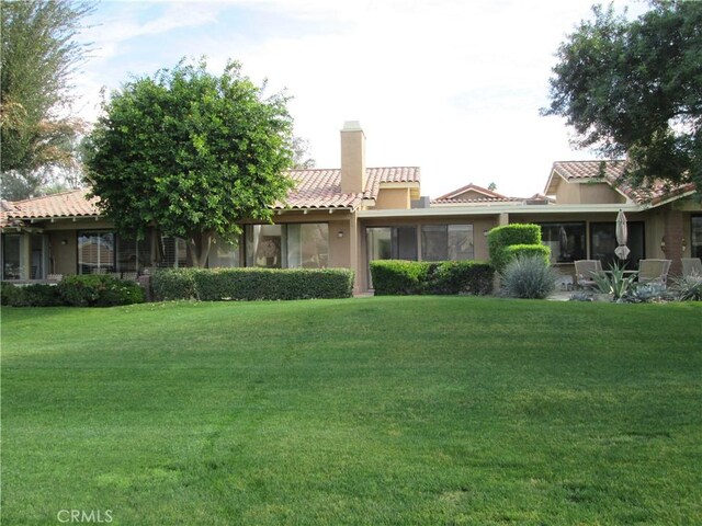 263 Serena Dr, Palm Desert, CA 92260 - view of front of property featuring a tile roof, a chimney, stucco siding, and a front lawn
