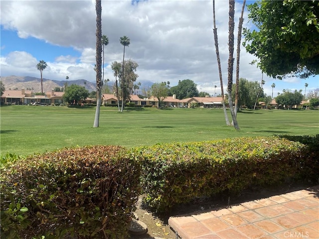 view of home's community featuring a mountain view, a yard, and a residential view