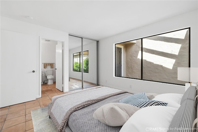 bedroom featuring tile patterned floors, a closet, and ensuite bathroom