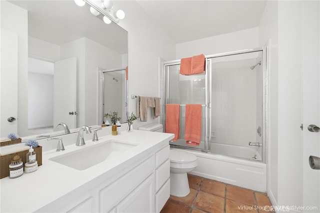 bathroom featuring toilet, shower / bath combination with glass door, tile patterned flooring, and vanity