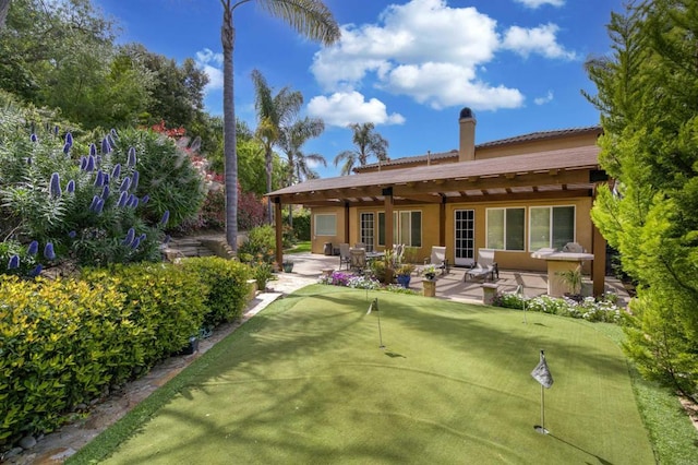 2927 Rancho Cortes, Carlsbad, CA 92009 - rear view of property featuring a patio, a putting green, a chimney, and stucco siding