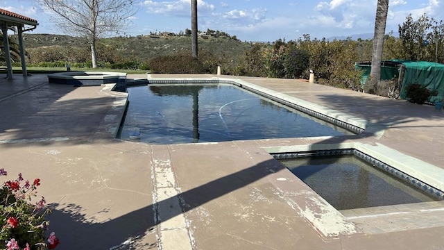 view of pool with a patio and a pool with connected hot tub