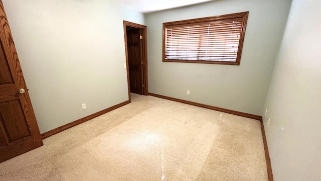unfurnished bedroom featuring baseboards and light colored carpet