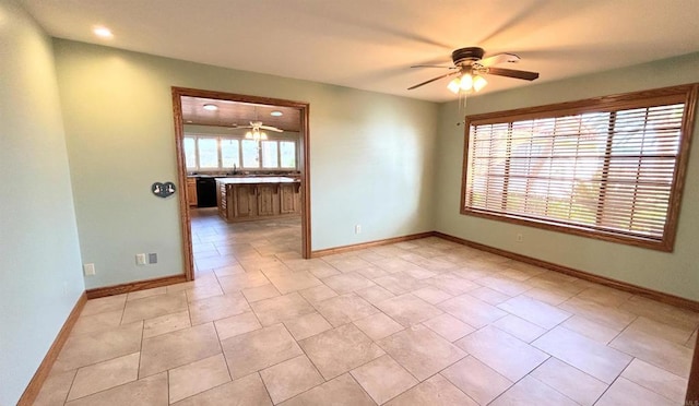 spare room with ceiling fan and baseboards