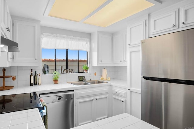 5170 Clairemont Mesa Blvd Unit 27, San Diego, CA 92117 - kitchen with appliances with stainless steel finishes, tile counters, white cabinetry, and under cabinet range hood