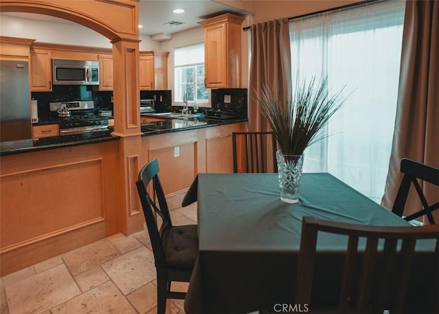 1153 San Rafael Ave Unit 105, Glendale, CA 91202 - kitchen with dark countertops, decorative backsplash, a sink, and stainless steel appliances