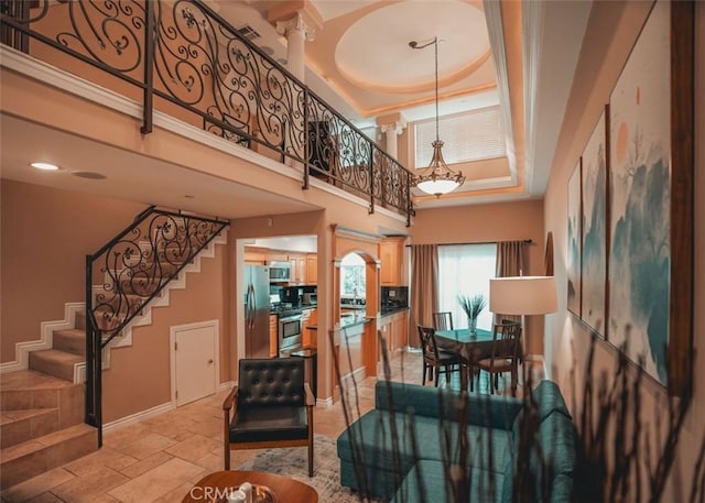 1153 San Rafael Ave Unit 105, Glendale, CA 91202 - interior space featuring a towering ceiling, baseboards, stairway, a raised ceiling, and stone tile floors