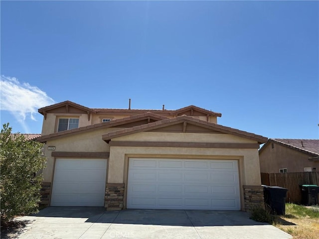 3324 Rosegold Ave, Rosamond, CA 93560 - view of front facade featuring fence, stucco siding, driveway, and stone siding