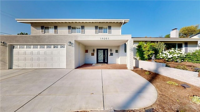 19201 Barrett Ln, North Tustin, CA 92705 - view of front of home with stucco siding, driveway, brick siding, and an attached garage