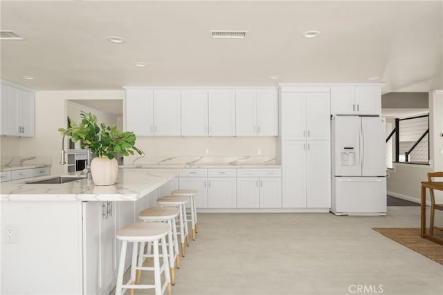 19201 Barrett Ln, North Tustin, CA 92705 - kitchen featuring white fridge with ice dispenser, white cabinets, light stone countertops, and recessed lighting