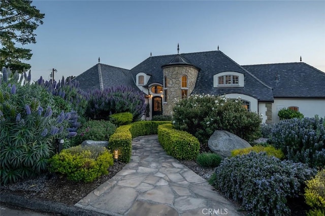 french country home with stone siding and stucco siding