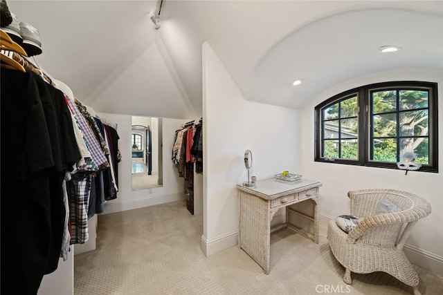 spacious closet with light colored carpet and lofted ceiling