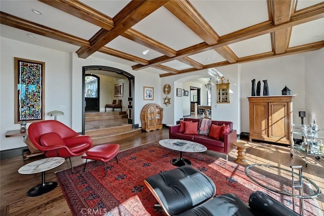 living area featuring coffered ceiling, arched walkways, wood finished floors, and beamed ceiling