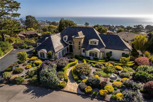 french country home featuring a water view, stucco siding, and stone siding