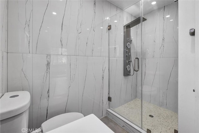 bathroom featuring a marble finish shower and toilet