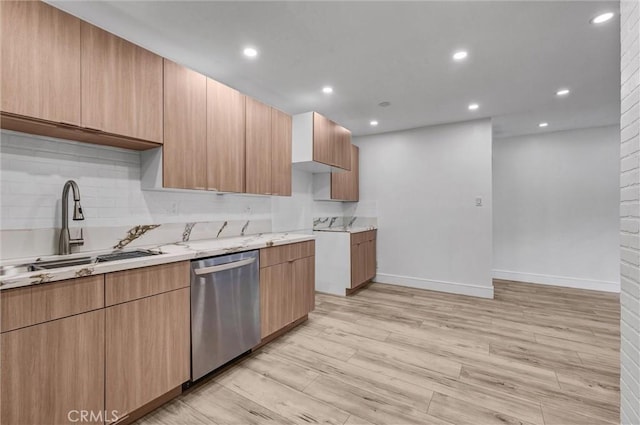 kitchen featuring light wood-style floors, dishwasher, a sink, baseboards, and backsplash