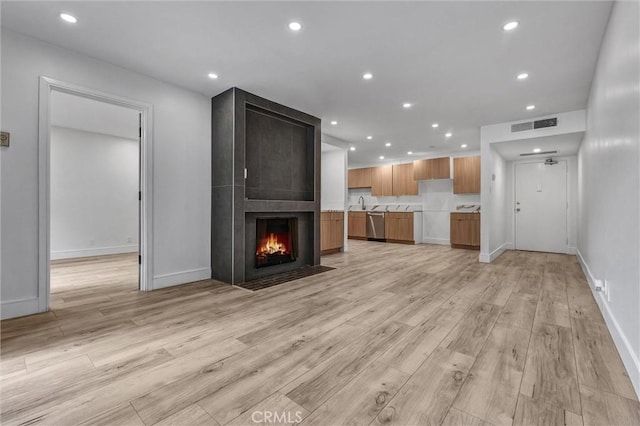unfurnished living room with light wood finished floors, baseboards, visible vents, and recessed lighting