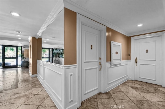 corridor with crown molding, stone tile flooring, recessed lighting, and a decorative wall