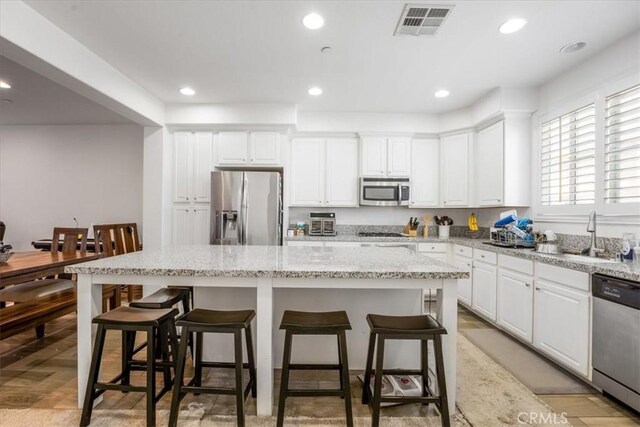 40925 Lacroix Ave, Murrieta, CA 92562 - kitchen with visible vents, a sink, a kitchen bar, stainless steel appliances, and a kitchen island