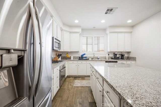 40925 Lacroix Ave, Murrieta, CA 92562 - kitchen featuring stainless steel appliances, visible vents, white cabinetry, and wood finished floors
