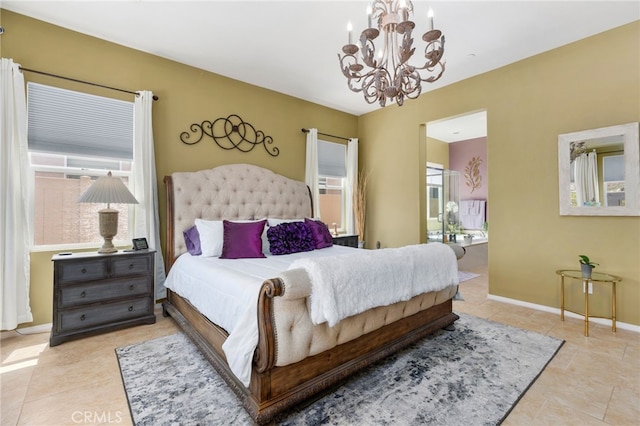 tiled bedroom with a notable chandelier, baseboards, and connected bathroom