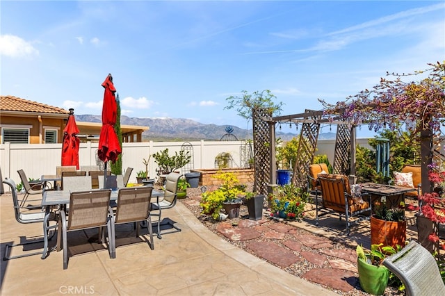 view of patio / terrace with a mountain view, a fenced backyard, and outdoor dining space