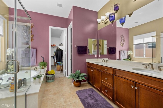 bathroom with tile patterned flooring, double vanity, a bath, and a sink