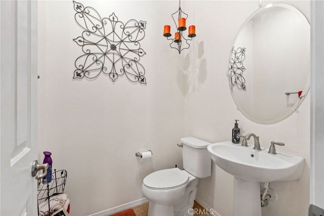 half bathroom featuring toilet and baseboards