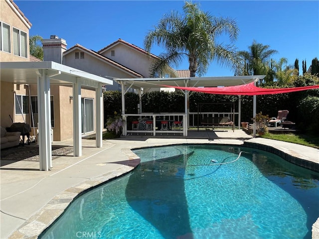 outdoor pool with a patio area and a pergola