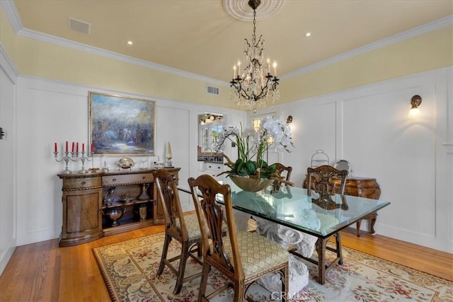 1239 S Patton Ave, San Pedro, CA 90731 - dining room featuring a chandelier, light wood-type flooring, crown molding, and a decorative wall