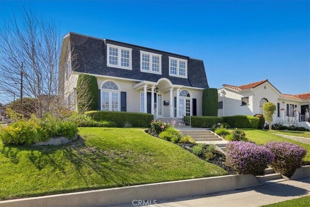 1239 S Patton Ave, San Pedro, CA 90731 - view of front of house featuring a shingled roof, stucco siding, a front lawn, and mansard roof