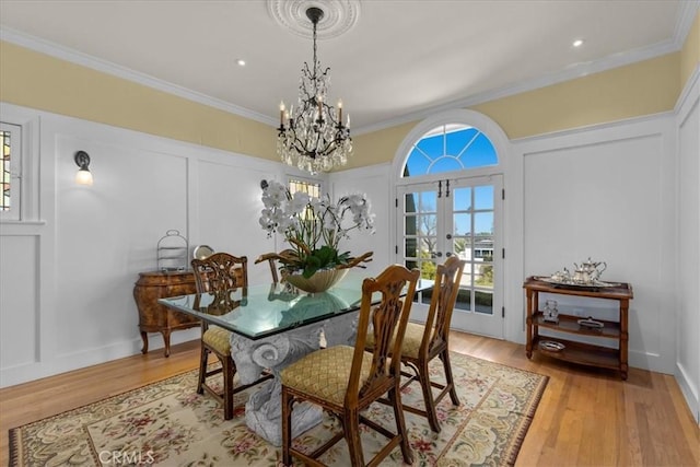 1239 S Patton Ave, San Pedro, CA 90731 - dining area with french doors, a chandelier, a decorative wall, ornamental molding, and light wood-style floors