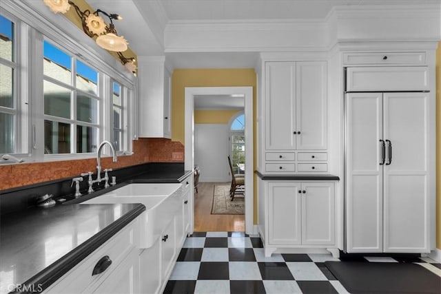 1239 S Patton Ave, San Pedro, CA 90731 - kitchen with paneled refrigerator, dark flooring, white cabinets, plenty of natural light, and ornamental molding