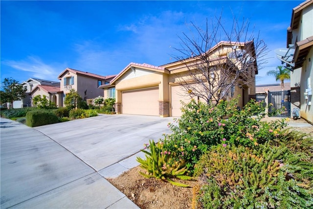 view of front of property with a tile roof, an attached garage, driveway, and stucco siding