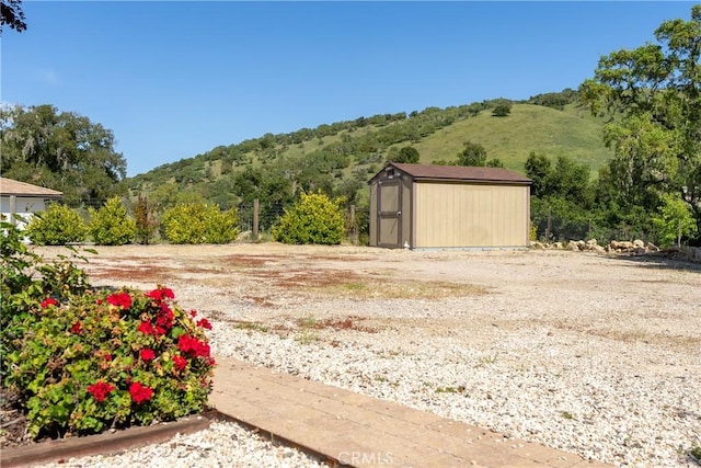 view of yard with an outdoor structure, a mountain view, and a shed