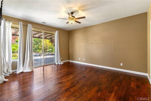 spare room with ceiling fan, baseboards, dark wood-style floors, and visible vents