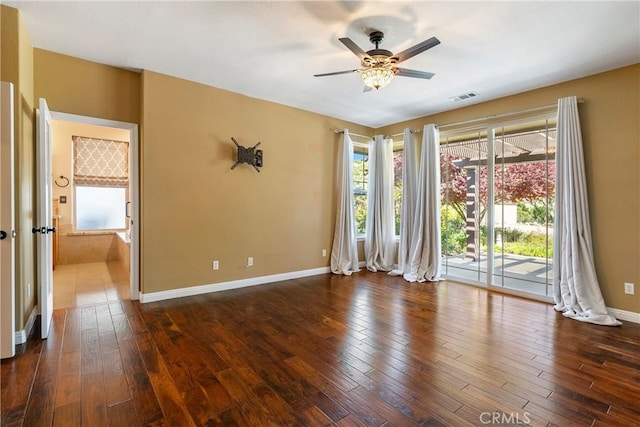unfurnished room featuring plenty of natural light, a ceiling fan, visible vents, and baseboards