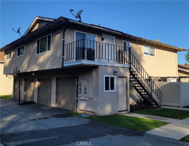 exterior space with stairway, stucco siding, and driveway