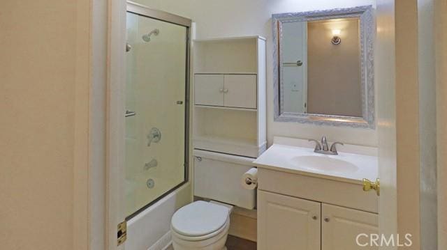 bathroom with toilet, vanity, and enclosed tub / shower combo