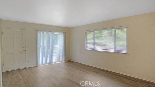 spare room featuring baseboards and wood finished floors