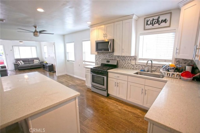 kitchen with a sink, a ceiling fan, recessed lighting, stainless steel appliances, and backsplash
