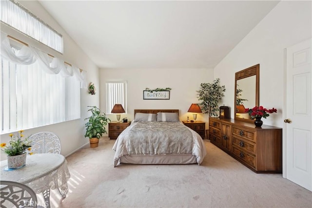 carpeted bedroom with high vaulted ceiling