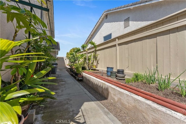 view of home's exterior with stucco siding and fence