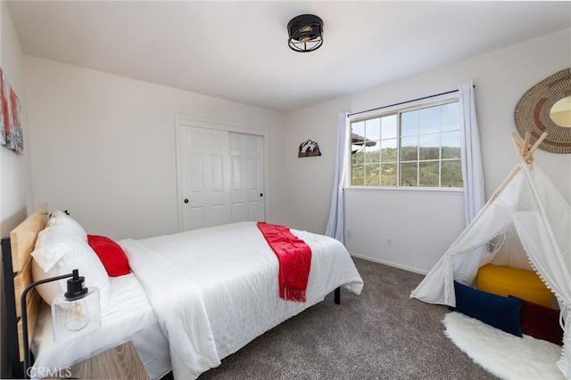carpeted bedroom featuring a closet and baseboards